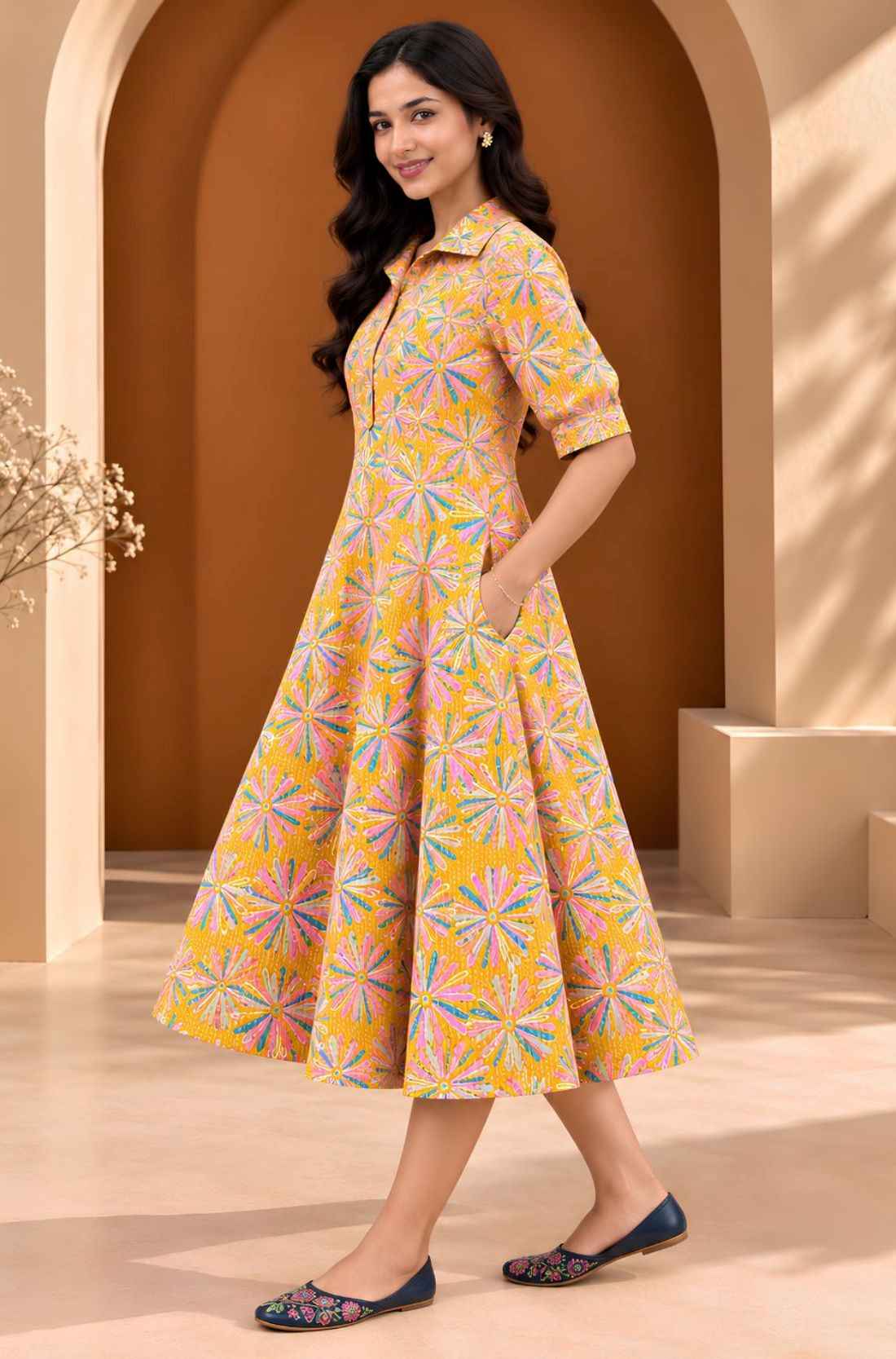 Side view of ochre yellow Jaipur floral print cotton A-line midi dress with elbow-length sleeves, flared hem and side pocket.