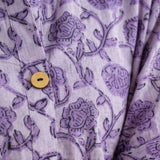 Close-up detail of lavender floral block print cotton shirt highlighting wooden buttons and handcrafted print.