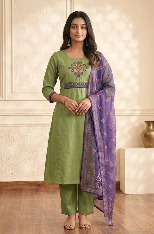 Front view of a model in a light green cotton cross stitch embroidered kurta set with straight pants and a sheer purple dupatta