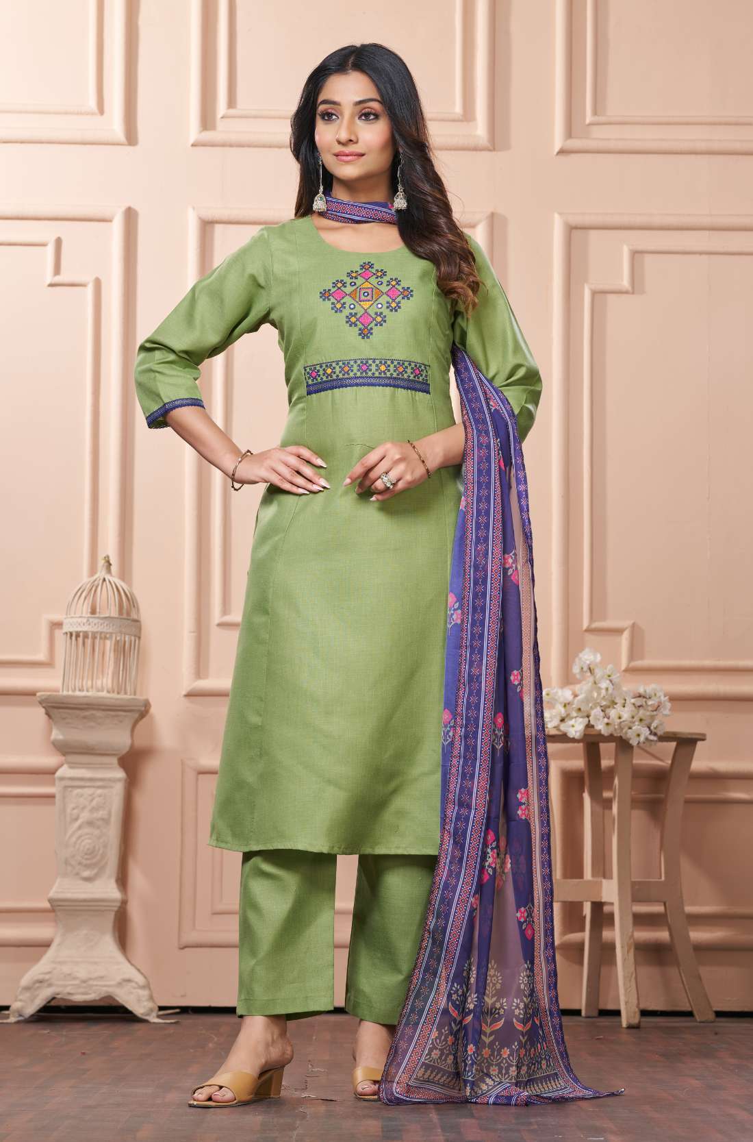 Side view of a model showcasing the straight silhouette, side slits, and comfortable trouser fit of a light green embroidered cotton kurta set paired with a draped patterned dupatta