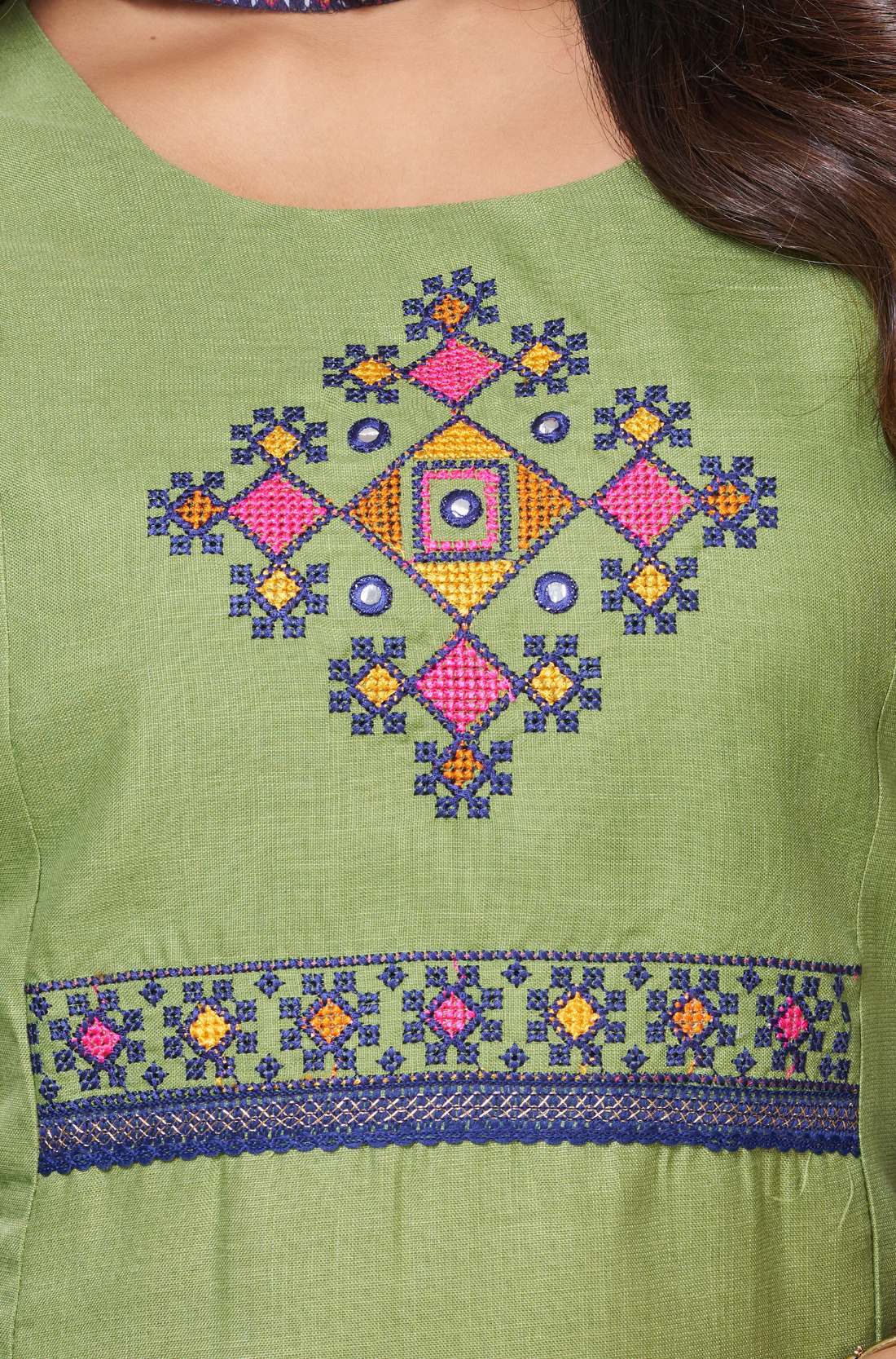 Detailed view of the intricately designed front yoke section on a light green cotton kurta featuring precise geometric and floral cross stitch needlework