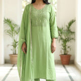 Front full length view of a woman wearing a light green embroidered kurta set with straight pants and a matching printed dupatta