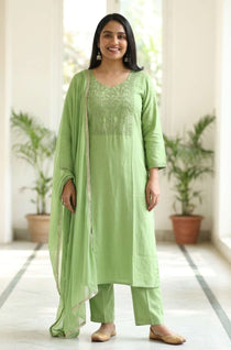 Front full length view of a woman wearing a light green embroidered kurta set with straight pants and a matching printed dupatta