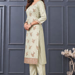 Side view of women's light green embroidered silk blend kurta set with matching pants and dupatta.
