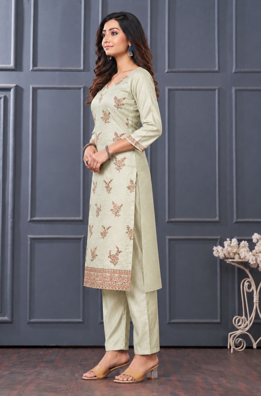 Side view of women's light green embroidered silk blend kurta set with matching pants and dupatta.