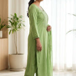 Side profile view of a model in a light green embroidered salwar suit showcasing the side slit and elegant dupatta drape