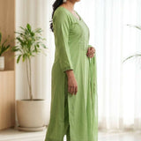 Side profile view of a model in a light green embroidered salwar suit showcasing the side slit and elegant dupatta drape