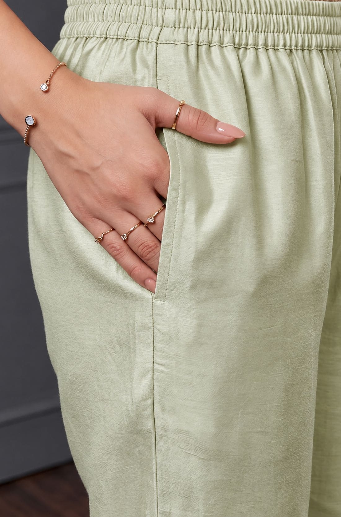 Close-up of the side pocket and elasticated waistband of light green pants from a women's kurta set.