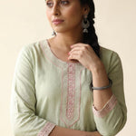 Close-up shot of a light green straight-fit kurta highlighting elegant pastel pink floral embroidery along the rounded keyhole neckline panel and matching embroidered lace borders on the three-quarter sleeves.