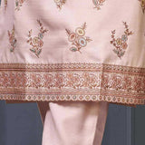 Close-up of floral embroidery and decorative scalloped border on a light pink silk blend kurta for women.