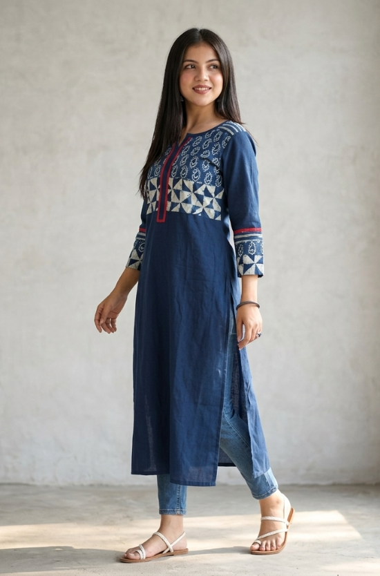 Full body side profile of a woman styling a long blue kurti with side slits and casual blue denim jeans.