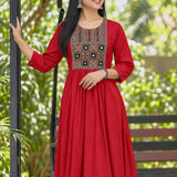 A model wearing a full-length maroon rayon A-line kurta featuring 3/4 sleeves and a geometric embroidered yoke