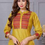 Close up detail of the intricate thread embroidery on the contrast neck yoke of the ochre yellow cotton straight kurta