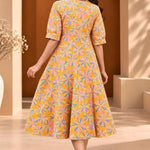 Back view of ochre yellow floral printed cotton midi dress showing the all-over Jaipur floral pattern and flared A-line silhouette.