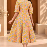 Back view of ochre yellow floral printed cotton midi dress showing the all-over Jaipur floral pattern and flared A-line silhouette.