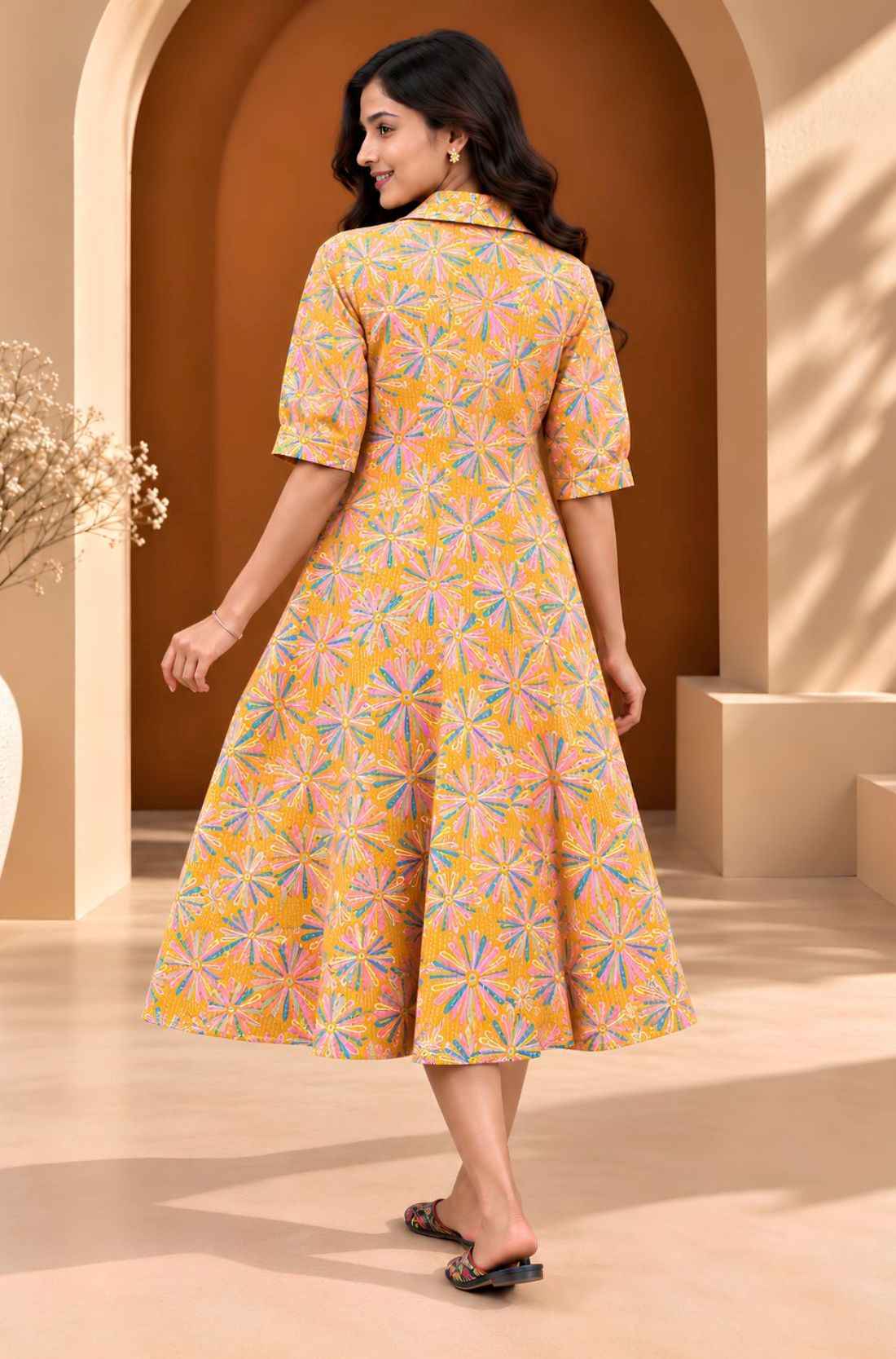 Back view of ochre yellow floral printed cotton midi dress showing the all-over Jaipur floral pattern and flared A-line silhouette.