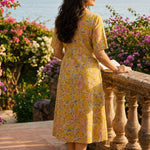Back view of ochre yellow printed cotton frock style kurti with elbow sleeves and flared silhouette