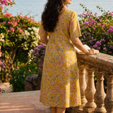 Back view of ochre yellow printed cotton frock style kurti with elbow sleeves and flared silhouette