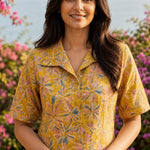 Close-up of ochre yellow printed cotton frock style kurti with collar neck and elbow sleeves