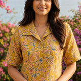 Close-up of ochre yellow printed cotton frock style kurti with collar neck and elbow sleeves