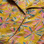 Close-up of ochre yellow printed cotton frock style kurti showing Jaipur floral print and fabric detail