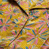 Close-up of ochre yellow printed cotton frock style kurti showing Jaipur floral print and fabric detail