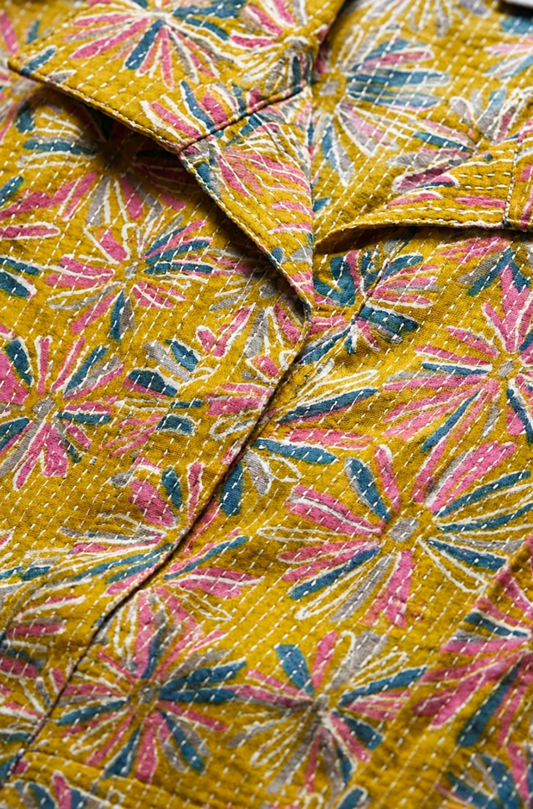 Close-up of ochre yellow printed cotton frock style kurti showing Jaipur floral print and fabric detail