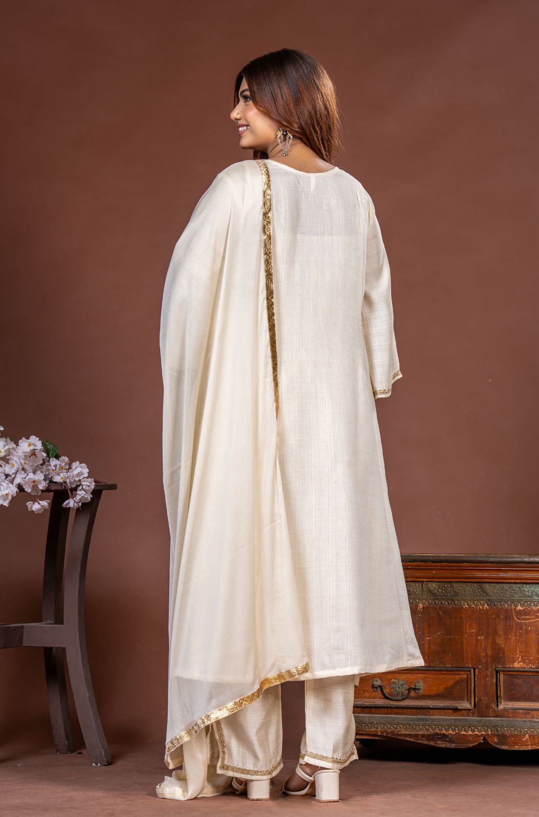 Back view of off white A-line kurta set with straight pants and gold-bordered chiffon dupatta