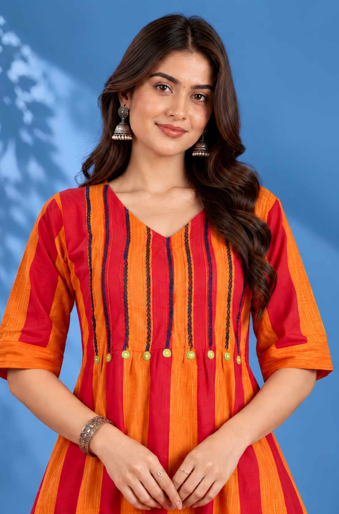 Close-up view of the V-neck and yoke featuring intricate thread embroidery and pintuck detailing on the orange handloom cotton midi dress for women.