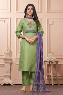A full length presentation of a green cotton ethnic suit set displaying vibrant cross stitch embroidery details along the front panel, styled with straight pants and a printed dupatta