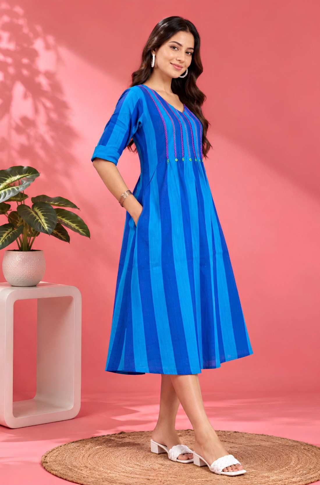 Side profile of a model showcasing the convenient pocket and elegant drape of the Philippine Blue handloom cotton pintuck midi dress.
