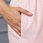 Close up view highlighting the convenient functional side utility pocket tailored into the straight pants of a pink pure cotton pintucks kurta set, showing a hand resting inside the pocket.