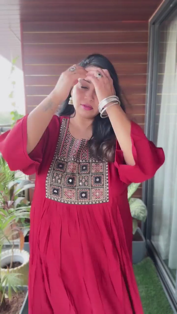 It is a video of a plus-size woman wearing a mirror-work maroon kurta showing its yoke detail and styling effortlessly