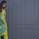 Women’s yellow cotton 3-piece kurta pant dupatta set featuring a straight-fit embroidered kurta, matching pants, and turquoise floral printed dupatta.