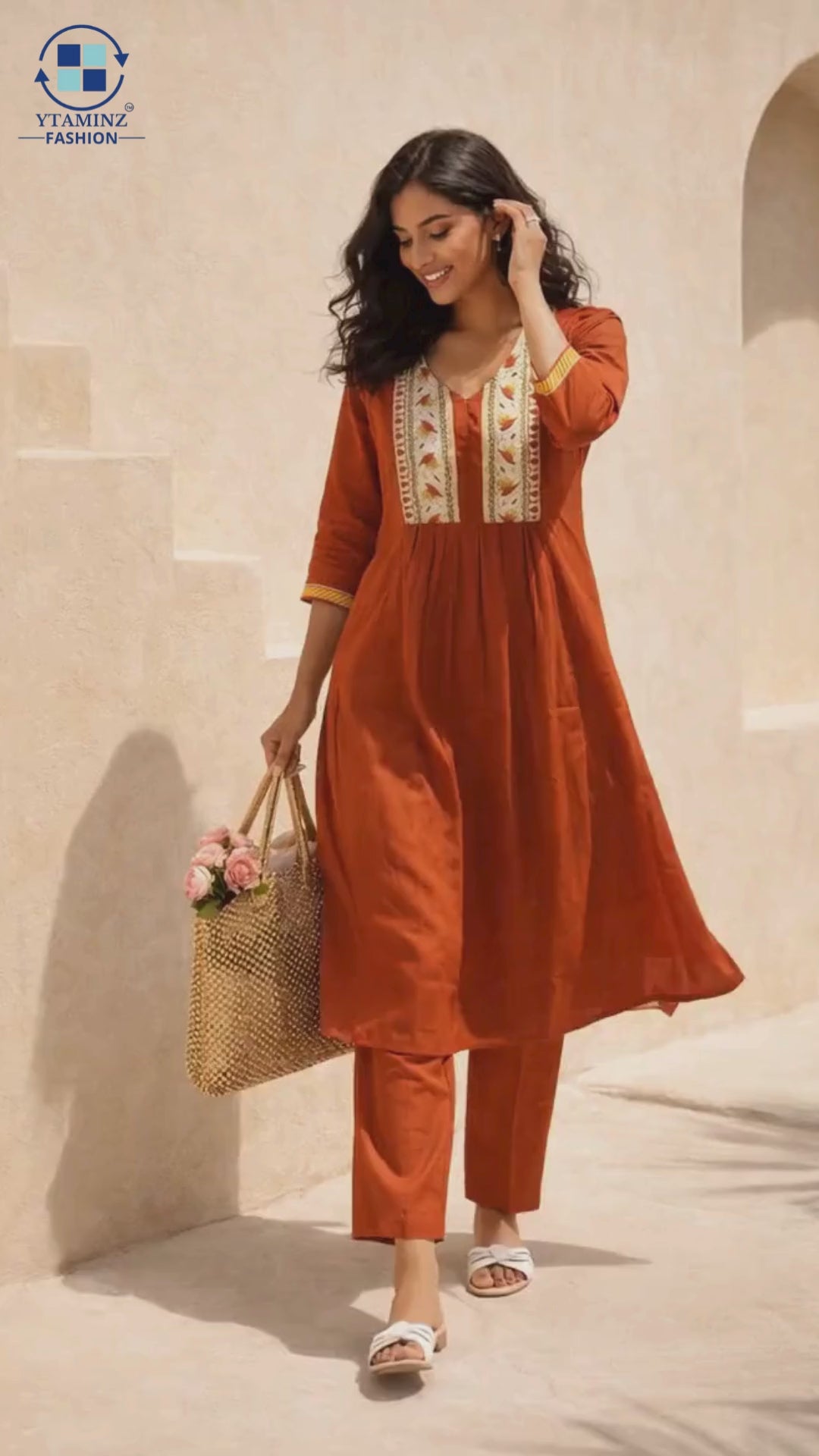It is a video of a woman who wore an orange kurta set, flaring and posing to show the dress