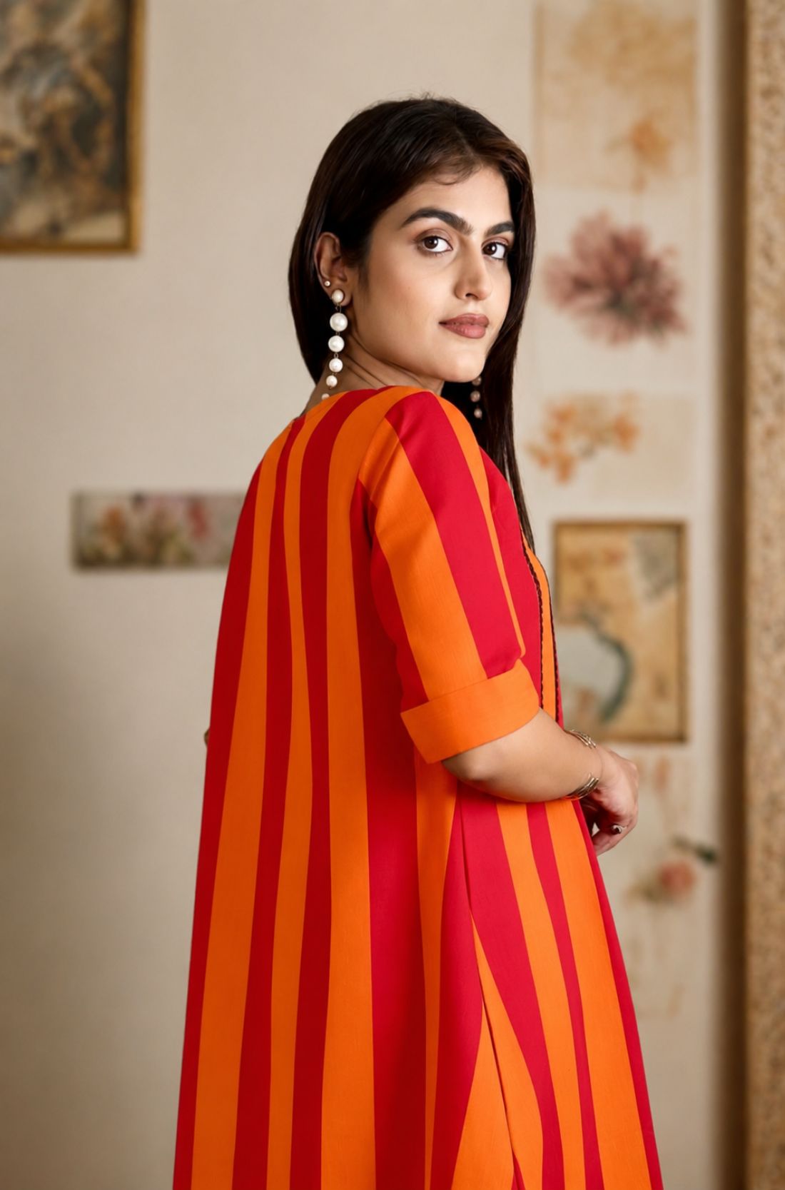 Side profile of the model wearing the orange pure handloom cotton tunic, highlighting the striped pattern and folded cuff sleeves.