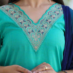 Close-up of Rama Green cotton kurta set for women featuring intricate thread embroidery on the scalloped V-neckline with a contrasting navy blue Banarasi silk dupatta.