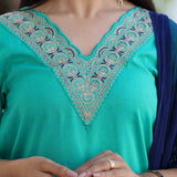 Close-up of Rama Green cotton kurta set for women featuring intricate thread embroidery on the scalloped V-neckline with a contrasting navy blue Banarasi silk dupatta.