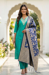 Front full-length view of a model in a premium rama green embroidered straight kurta set, featuring intricate white thread embroidery on the neckline yoke, paired with matching pants and a printed dupatta.