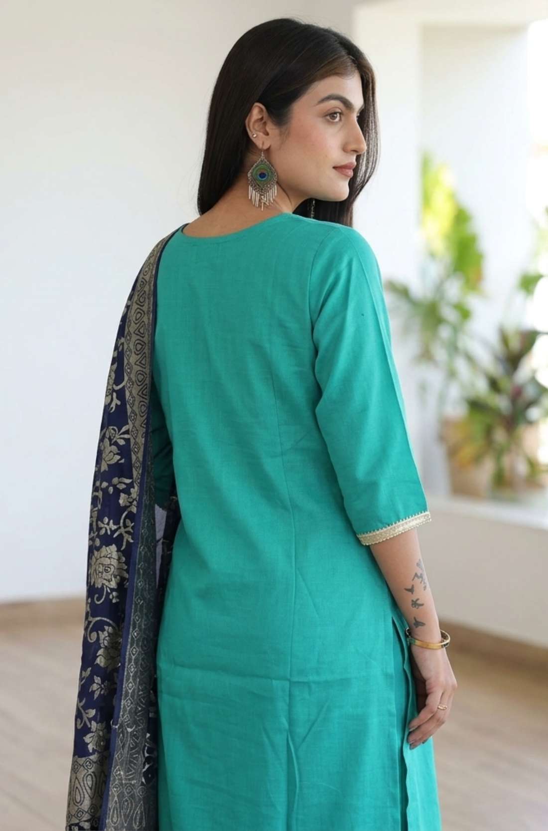 Back view of the straight fit rama green embroidered kurta suit showcasing the matching trousers and drape of the dupatta