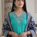 Left side angled view of a woman posing in a premium rama green embroidered kurta set displaying the complete outfit
