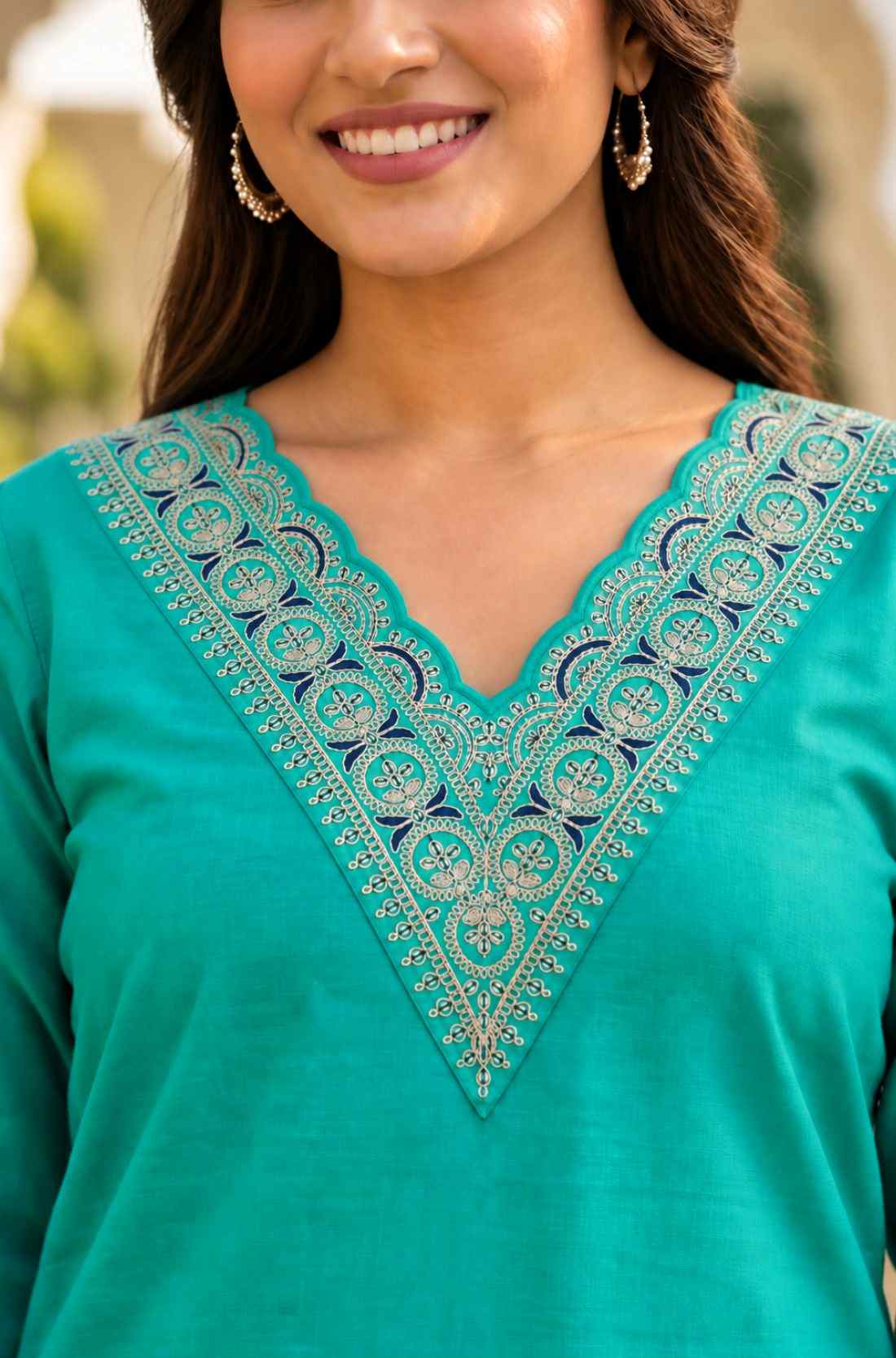Close-up of intricate thread and sequin embroidery on the scalloped V-neckline of a Rama Green cotton kurta