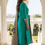 Side profile of woman wearing Rama Green straight kurta and trouser set with tasselled Banarasi silk dupatta