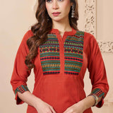 Close up detail of the intricate thread embroidery on the contrast neck yoke of the rust orange cotton straight kurta