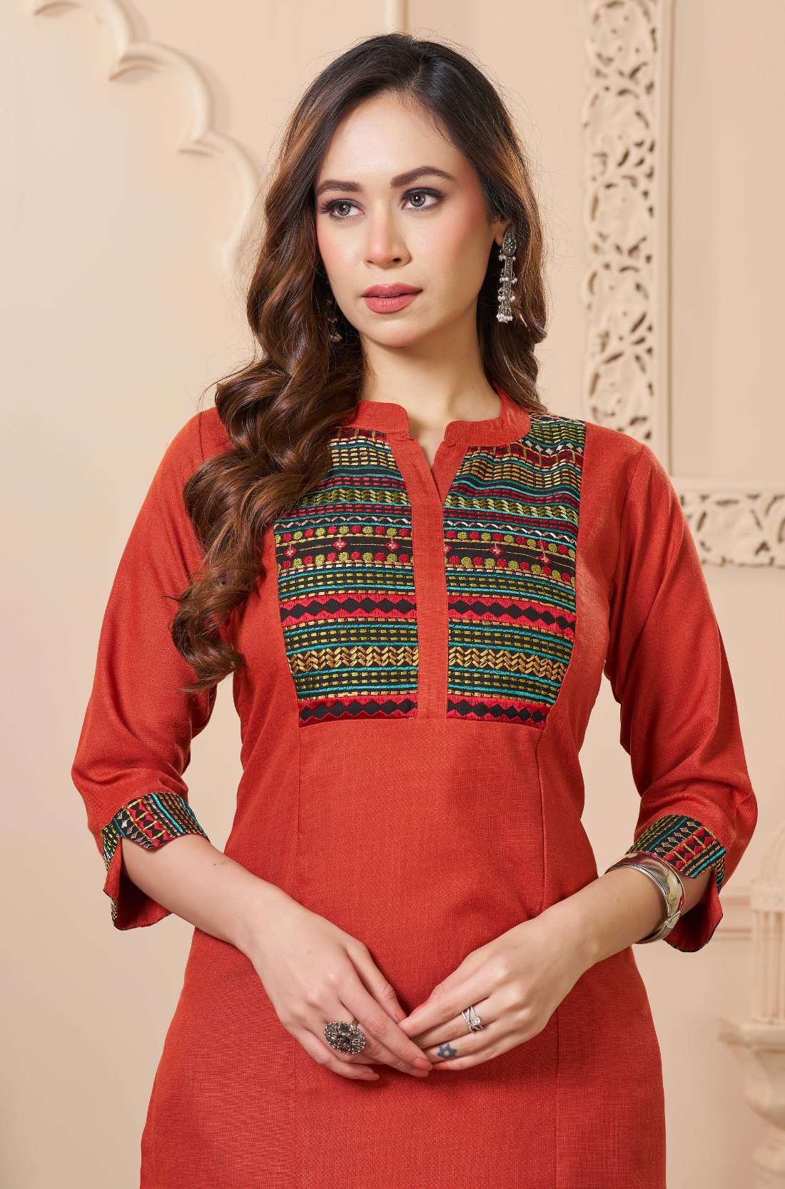 Close up detail of the intricate thread embroidery on the contrast neck yoke of the rust orange cotton straight kurta