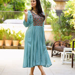 Model wearing sea green art silk flared kurti with aari embroidered yoke and gathered waist