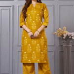 Front full length view of a model wearing an ochre yellow straight fit floral print cotton kurta set with coordinating chevron pants and a printed dupatta