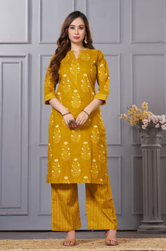 Front full length view of a model wearing an ochre yellow straight fit floral print cotton kurta set with coordinating chevron pants and a printed dupatta
