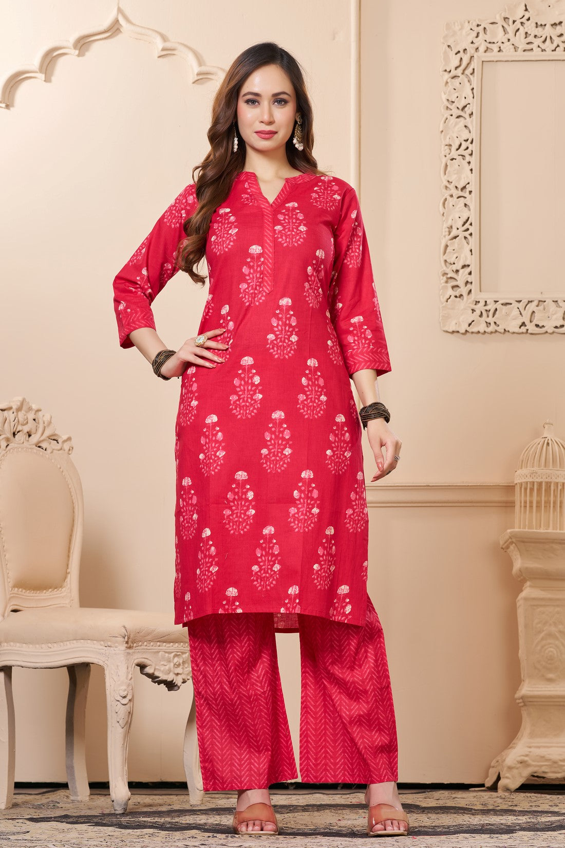 Front full length view of a model wearing a rani pink straight fit floral print cotton kurta set with matching chevron pants and a printed dupatta