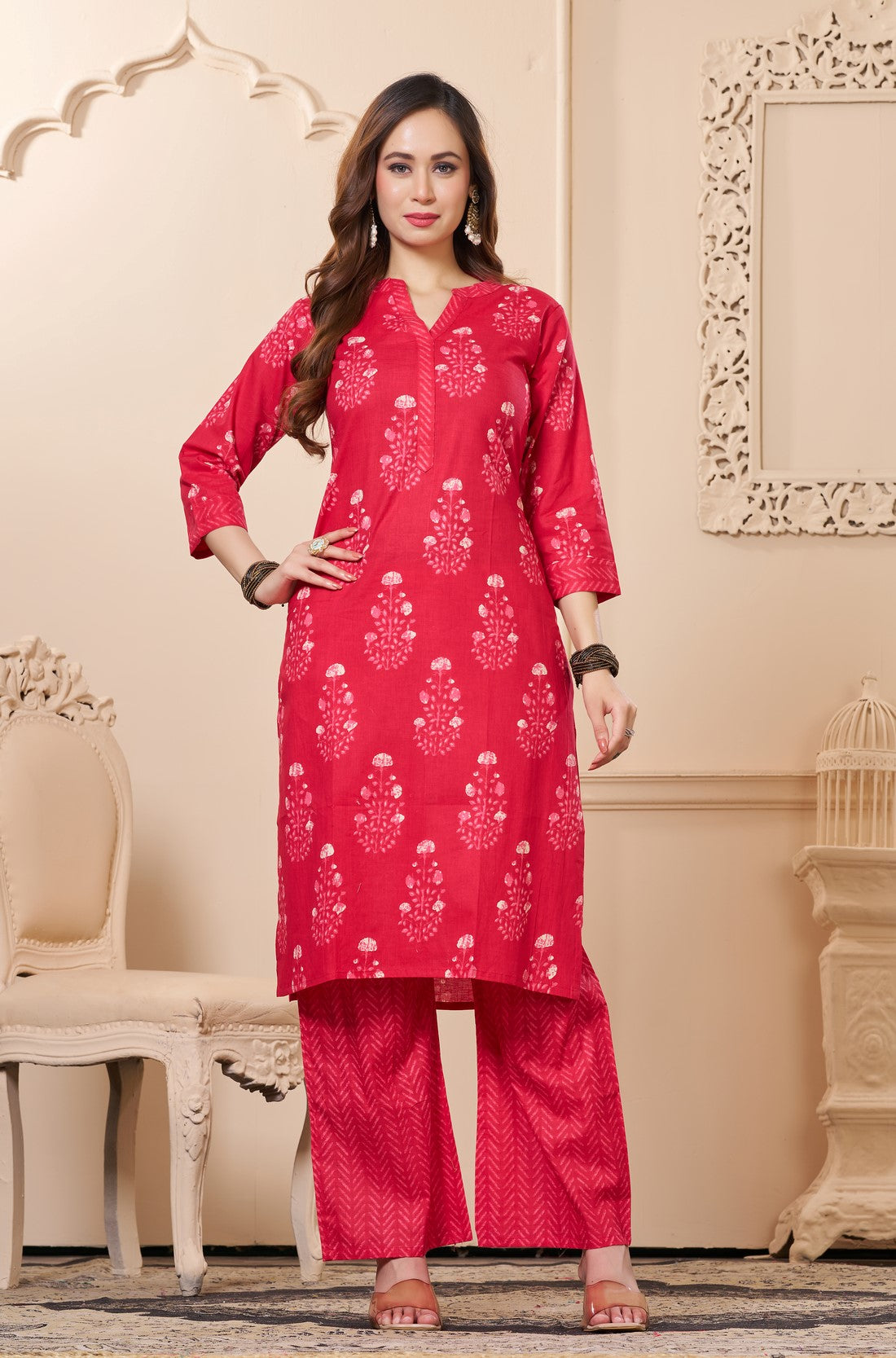 Front full length view of a model wearing a rani pink straight fit floral print cotton kurta set with matching chevron pants and a printed dupatta